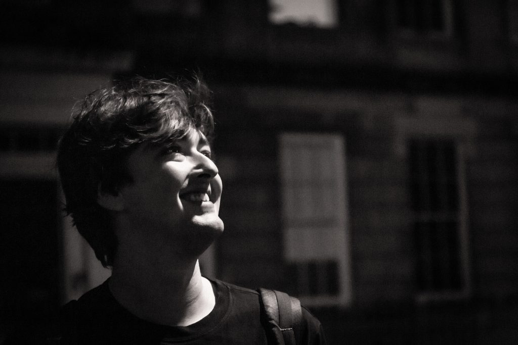 Black and white photo of David Hewitson standing in a street